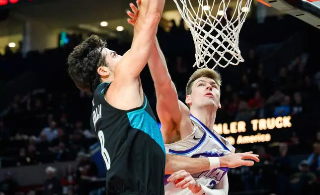 Portland Trail Blazers forward Deni Avdija (8) is fouled by Utah Jazz center Kyle Filipowski, right, during the first half of an NBA basketball game, Monday, Jan. 5, 2026, in Portland, Ore. (AP Photo/Molly J. Smith)