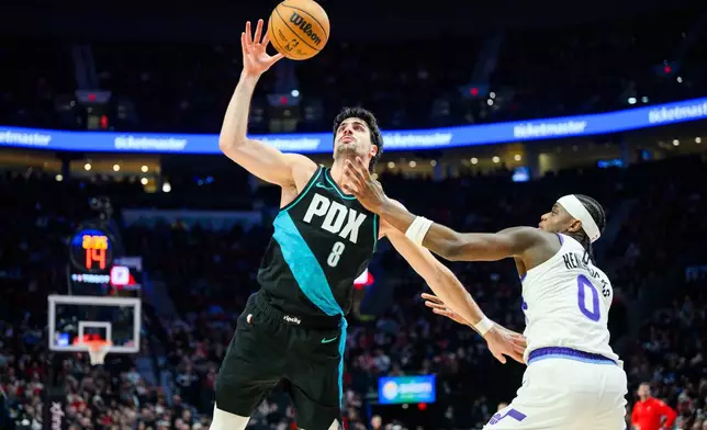 Portland Trail Blazers forward Deni Avdija (8) grabs control of the ball over Utah Jazz forward Taylor Hendricks (0) during the first half of an NBA basketball game, Monday, Jan. 5, 2026, in Portland, Ore. (AP Photo/Molly J. Smith)