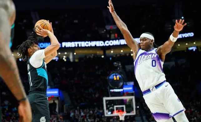 Portland Trail Blazers guard Shaedon Sharpe, left, prepares to shoot a 3-point basket past Utah Jazz forward Taylor Hendricks (0) during the first half of an NBA basketball game, Monday, Jan. 5, 2026, in Portland, Ore. (AP Photo/Molly J. Smith)
