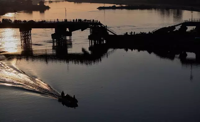 People cross a damaged bridge over the Euphrates River in Raqqa, Syria, Sunday, Jan. 25, 2026. (AP Photo/Ghaith Alsayed)