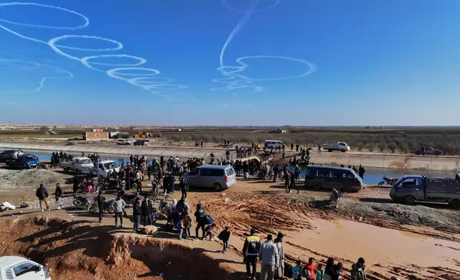 FILE - Displaced Syrians gather near a river crossing close to the village of Rasm al-Harmil al-Imam in the eastern Aleppo countryside, near the front line with the Kurdish-led Syrian Democratic Forces, in Deir Hafer, Syria, Friday, Jan. 16, 2026. Aerial pattern from unknown source. (AP Photo/Ghaith Alsayed)