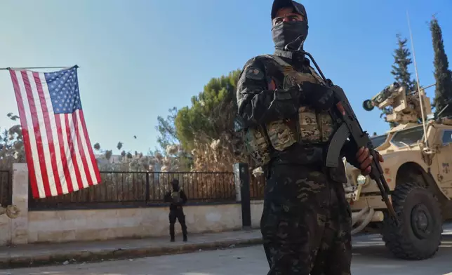FILE - A fighter with the Syrian Democratic Forces (SDF) stands guard during a meeting with the U.S.-led coalition against the Islamic State group in Deir Hafer, Syria, Friday, Jan. 16, 2026. (AP Photo/Baderkhan Ahmad)