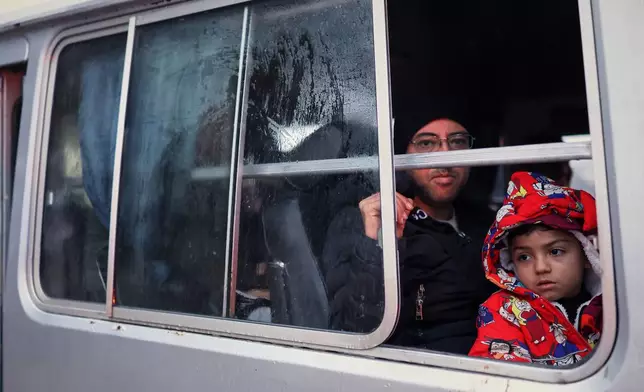 FILE - Displaced residents look out from a bus window as they return to the Achrafieh neighborhood after days of fighting between government forces and Kurdish fighters in the northern city of Aleppo, Syria, Monday, Jan. 12, 2026. (AP Photo/Ghaith Alsayed)
