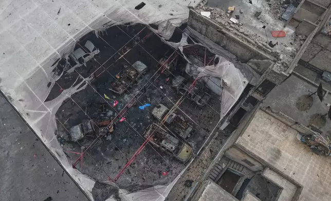 FILE - An aerial view shows destroyed vehicles in a building in the area of the predominantly Kurdish Sheikh Maqsoud neighborhood where clashes broke out Tuesday Jan. 6 between government forces and the Kurdish-led Syrian Democratic Forces in the northern city of Aleppo, Syria, Monday, Jan. 12, 2026. (AP Photo/Omar Albam)