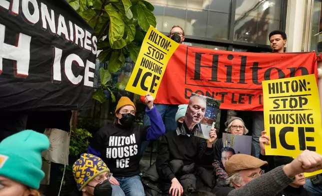 Protesters stage a sit-in in the lobby of a Hilton Garden Inn in New York, Tuesday, Jan. 27, 2026. (AP Photo/Seth Wenig)