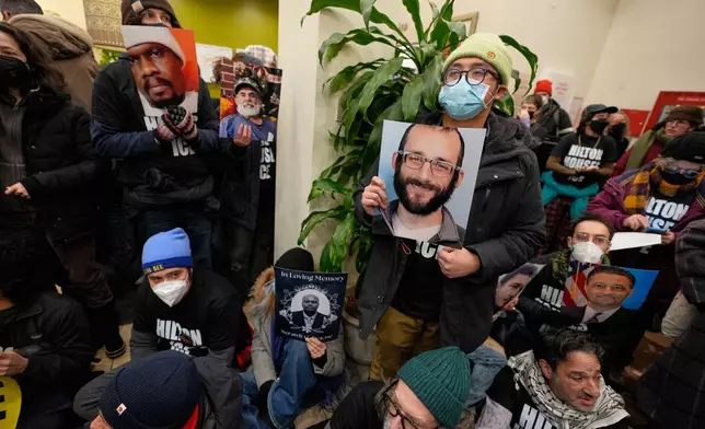 Protesters stage a sit-in in the lobby of a Hilton Garden Inn in New York, Tuesday, Jan. 27, 2026. (AP Photo/Seth Wenig)
