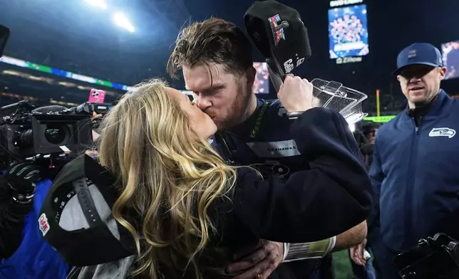 Seattle Seahawks quarterback Sam Darnold kisses his girlfriend Katie Hoofnagle after a win over the Los Angeles Rams in the NFC Championship NFL football game Sunday, Jan. 25, 2026, in Seattle. (AP Photo/Lindsey Wasson)