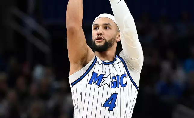 Orlando Magic guard Jalen Suggs (4) goes up to shoot a 3-pointer during the first half of an NBA basketball game against the Cleveland Cavaliers, Saturday, Jan. 24, 2026, in Orlando, Fla. (AP Photo/Phelan M. Ebenhack)
