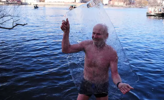 Polar swimmer holds up a block of ice during the traditional Three Kings swim in the Vltava River in Prague, Czech Republic, Tuesday, Jan. 6, 2026. (AP Photo/Petr David Josek)