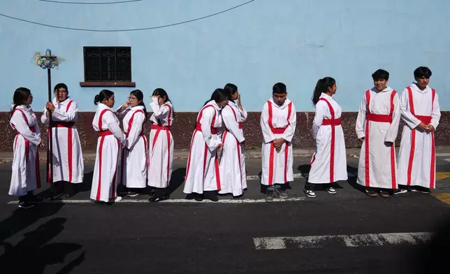 Altar boys line up to take part in a religious procession marking Three Kings Days, also known as feast day of The Epiphany, at the Guardia Viejo neighborhood in Guatemala City, Tuesday, Jan. 6, 2026. (AP Photo/Moises Castillo)