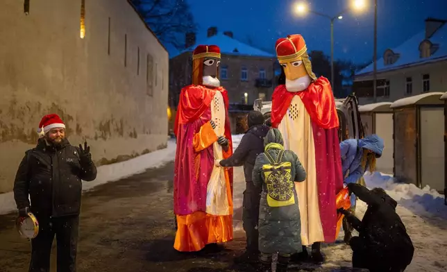 People prepare for a Three Kings parade during the Epiphany Day celebrations in Vilnius, Lithuania, Tuesday, Jan. 6, 2026. (AP Photo/Mindaugas Kulbis)