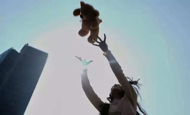 A child plays with the teddy bear she was gifted at an event celebrating Three Kings Day, at the Angel of Independence in Mexico City, Monday, Jan. 5, 2026. (AP Photo/Marco Ugarte)