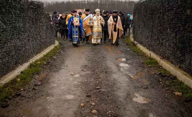 Orthodox archbishop Teodosie, centre, walks with clerics and faithful at the end of a religious service by the river Danube in Harsova, Romania, Monday, Jan. 5, 2026, a day ahead of the celebration of Epiphany. (AP Photo/Vadim Ghirda)