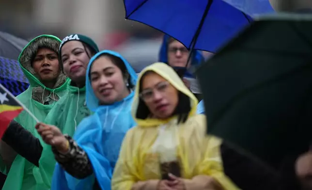 People wait for Pope Leo XIV to deliver the Angelus noon prayer from the central loggia of St. Peter's Basilica at the Vatican, Tuesday, Jan. 6, 2026. (AP Photo/Alessandra Tarantino)