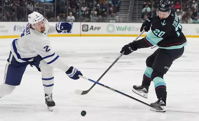 Toronto Maple Leafs defenseman Simon Benoit (2) tries to block a shot from Seattle Kraken right wing Eeli Tolvanen (20) during the third period of an NHL hockey game Thursday, Jan. 29, 2026, in Seattle. (AP Photo/Lindsey Wasson)