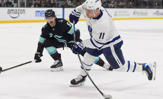 Toronto Maple Leafs center Max Domi (11) shoots as Seattle Kraken center Chandler Stephenson (9) looks on during the second period of an NHL hockey game Thursday, Jan. 29, 2026, in Seattle. (AP Photo/Lindsey Wasson)