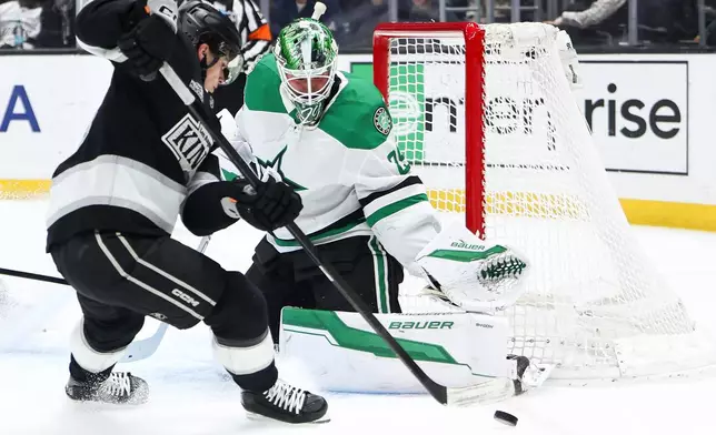Dallas Stars goaltender Jake Oettinger, right, makes a save against Los Angeles Kings center Alex Turcotte, left, during the second period of an NHL hockey game, Monday, Jan. 12, 2026, in Los Angeles. (AP Photo/Jessie Alcheh)