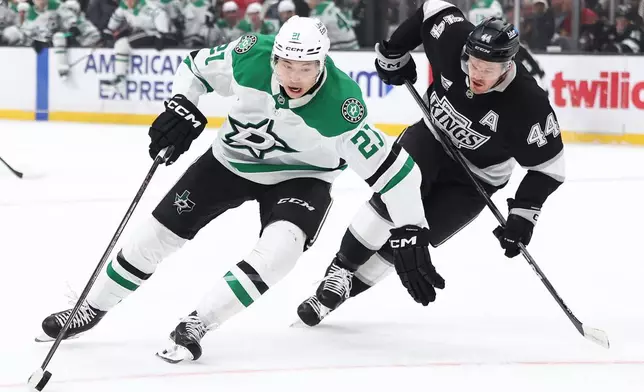 Dallas Stars left wing Jason Robertson (21) skates with the puck against Los Angeles Kings defenseman Mikey Anderson (44) during the first period of an NHL hockey game, Monday, Jan. 12, 2026, in Los Angeles. (AP Photo/Jessie Alcheh)