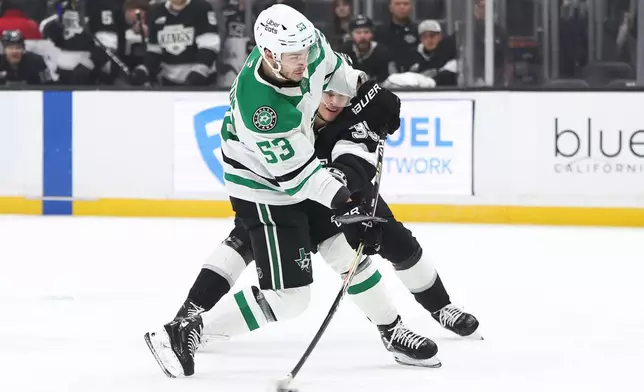 Dallas Stars center Wyatt Johnston (53) shoots against Los Angeles Kings left wing Jeff Malott, back right, during the first period of an NHL hockey game, Monday, Jan. 12, 2026, in Los Angeles. (AP Photo/Jessie Alcheh)