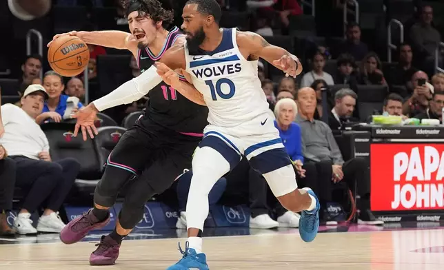 Miami Heat forward Jaime Jaquez Jr. (11) clashes with Minnesota Timberwolves guard Mike Conley (10) during the first half of an NBA basketball game, Saturday, Jan. 3, 2026, in Miami. (AP Photo/Rebecca Blackwell)