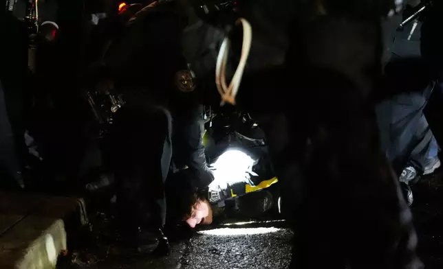 Law enforcement detain a protester outside the U.S. Immigration and Customs Enforcement facility on Thursday, Jan. 8, 2026, in Portland, Ore. (AP Photo/Jenny Kane)