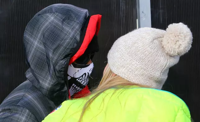 FILE - Tiger Woods, left, and Lindsey Vonn walk in the finish area of an alpine ski, women's World Cup super-G, in Cortina d'Ampezzo, Italy, Jan. 19, 2015. (AP Photo/Armando Trovati, File)