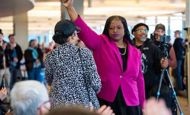Nekima Levy Armstrong holds up her fist after speaking at an anti-ICE rally for Martin Luther King Jr., Monday, Jan. 19, 2026, in St. Paul, Minn. (AP Photo/Angelina Katsanis)