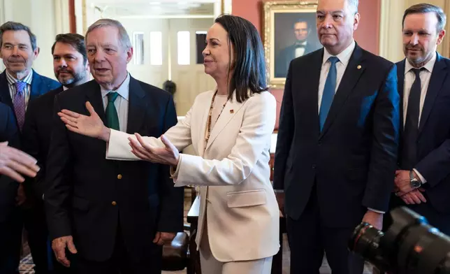 Venezuelan opposition leader Maria Corina Machado is welcomed at the Capitol before a meeting with senators, from left, Sen. John Curtis, R-Utah, Sen. Ruben Gallego, D-Ariz., Sen. Dick Durbin, D-Ill., Sen. Alex Padilla, D-Calif., and Sen. Chris Murphy, D-Conn., as the Nobel Peace Prize recipient visits American leaders two weeks after President Donald Trump toppled Venezuelan president Nicolas Maduro in a stunning military raid, at the Capitol in Washington, Thursday, Jan. 15, 2026. (AP Photo/J. Scott Applewhite)