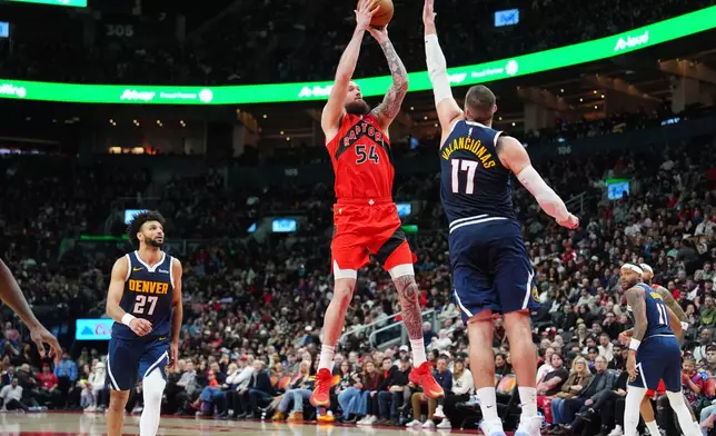 Toronto Raptors forward/center Sandro Mamukelashvili (54) shoots over Denver Nuggets center Jonas Valančiūnas (17) during the second half of an NBA basketball game in Toronto, Wednesday Dec. 31, 2025. (Frank Gunn/The Canadian Press via AP)