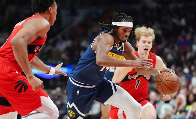 Denver Nuggets forward Daron Holmes II (14) drives up court between Toronto Raptors' Scottie Barnes, left, and Raptors guard Gradey Dick (1) during the first half of an NBA basketball game in Toronto on Wednesday, Dec. 31, 2025. (Frank Gunn/The Canadian Press via AP)