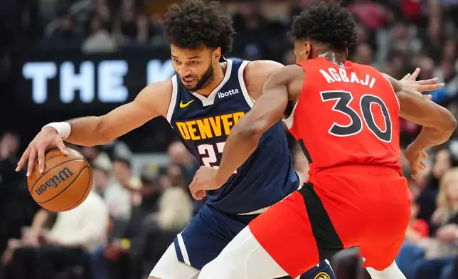 Denver Nuggets guard Jamal Murray (27) tries to get around Toronto Raptors guard Ochai Agbaji (30) during first half NBA action in Toronto on Wednesday Dec. 31, 2025. (Frank Gunn/The Canadian Press via AP)