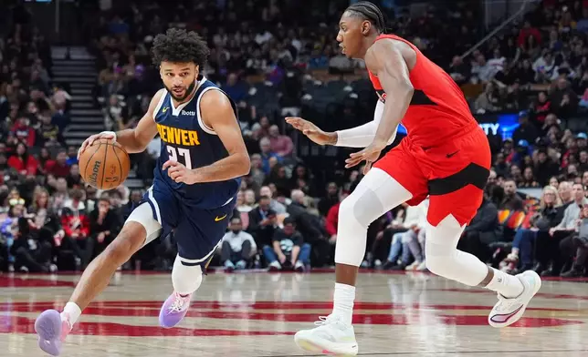 Denver Nuggets guard Jamal Murray (27) moves around Toronto Raptors forward/guard RJ Barrett, right, during first half NBA action in Toronto on Wednesday Dec. 31, 2025. (Frank Gunn/The Canadian Press via AP)