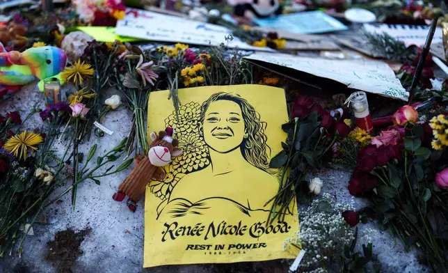 An image depicting Renee Good, who was fatally shot by an ICE officer last week, adorns a makeshift memorial for her in Minneapolis, Wednesday, Jan. 14, 2026. (AP Photo/Adam Gray)