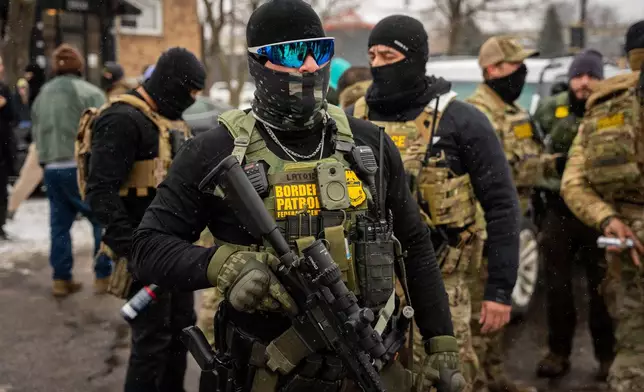 Federal agents stand guard, Wednesday, Jan. 21, 2026, in Minneapolis. (AP Photo/Angelina Katsanis)