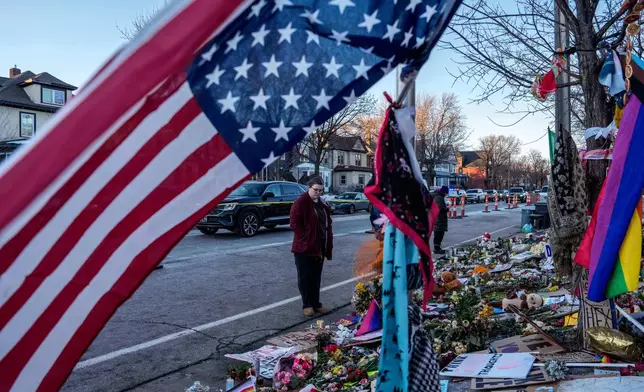 People visit a makeshift memorial for Renee Good, who was fatally shot by an ICE officer last week, Wednesday, Jan. 14, 2026, in Minneapolis. (AP Photo/Adam Gray)