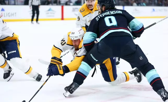 Nashville Predators center Ryan O'Reilly (90) reaches for the puck during a face off in the second period against the Seattle Kraken during an NHL hockey game, Thursday, Jan. 1, 2026, in Seattle. (AP Photo/Kevin Ng)