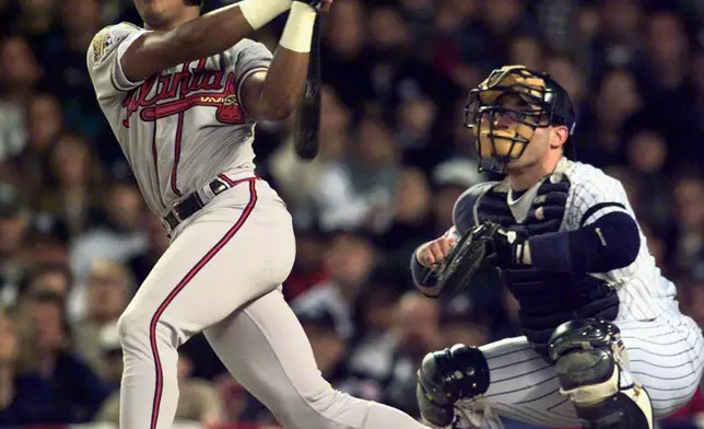 FILE - Atlanta Braves' Andruw Jones watches his home run in front of New York Yankees' catcher Jim Leyritz in the second inning of the World Series on Oct. 20, 1996, in New York. (AP Photo/Mark Lennihan, File)