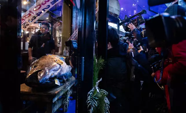 Members of the press take photographs of a bluefin tuna that won the highest bid at the annual New Year auction displayed at Sushi Zanmai restaurant in Tokyo, Monday, Jan. 5, 2026. (AP Photo/Louise Delmotte)
