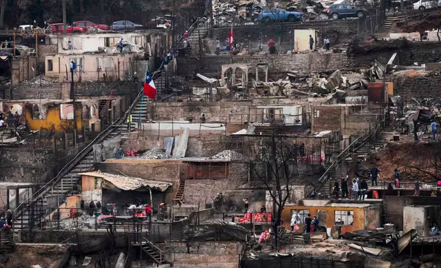 People salvage personnel belongings from their homes that were damaged by wildfires in Lirquen, Chile, Tuesday, Jan. 20, 2026. (AP Photo/Javier Torres)