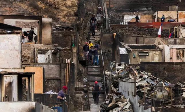 People salvage belongings from their homes that were damaged by wildfires in Lirquen, Chile, Tuesday, Jan. 20, 2026. (AP Photo/Javier Torres)