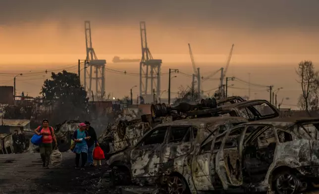 People transport food to victims of wildfires in Lirquen, Chile, Tuesday, Jan. 20, 2026. (AP Photo/Javier Torres)