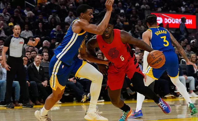 Portland Trail Blazers guard Jrue Holiday (5) moves the ball while defended by Golden State Warriors guard De'Anthony Melton (8) during the first half of an NBA basketball game, Tuesday, Jan. 13, 2026, in San Francisco. (AP Photo/Godofredo A. Vásquez)