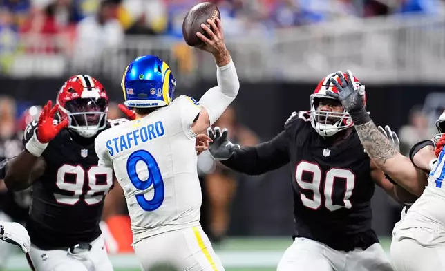 Los Angeles Rams quarterback Matthew Stafford (9) passes under pressure from Atlanta Falcons defensive tackle Ruke Orhorhoro (98) and defensive tackle David Onyemata (90) in the second half of an NFL football game, Monday, Dec. 29, 2025, in Atlanta. (AP Photo/Mike Stewart)