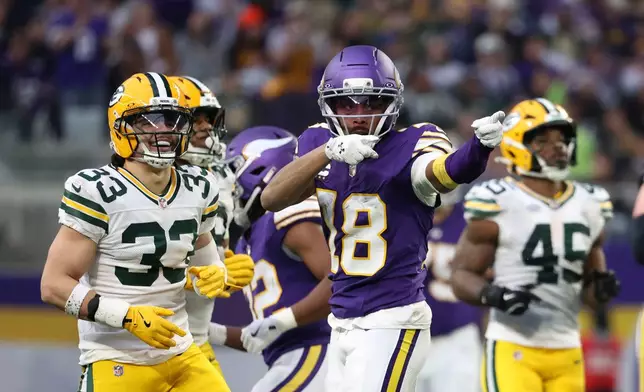 Minnesota Vikings wide receiver Justin Jefferson (18) celebrates in front of Green Bay Packers safety Evan Williams (33) after catching a pass during the first half of an NFL football game, Sunday, Jan. 4, 2026, in Minneapolis. (AP Photo/Ellen Schmidt)