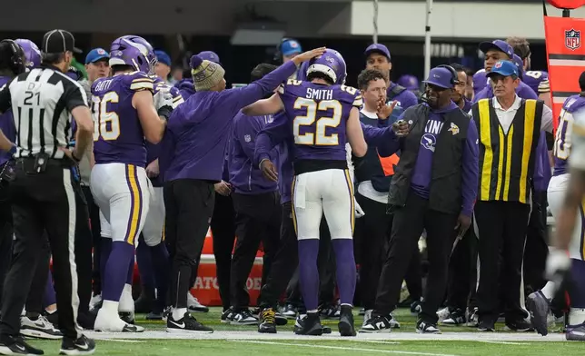 Minnesota Vikings safety Harrison Smith (22) reacts with coaches and teammates as he is taken out of the game during the second half of an NFL football game against the Green Bay Packers, Sunday, Jan. 4, 2026, in Minneapolis. (AP Photo/Ross D. Franklin)