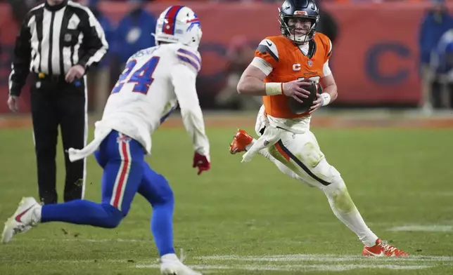 Denver Broncos quarterback Bo Nix, right, runs as Buffalo Bills safety Cole Bishop pursues in overtime of an NFL divisional football game Saturday, Jan. 17, 2026, in Denver. (AP Photo/David Zalubowski)