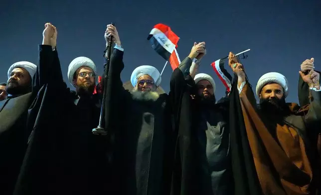 Shiite clerics wave Iraqi national flags during a protest against President Donald Trump's warning that the U.S. would no longer support the country if its former prime minister, Nouri al-Maliki, returns to power, at a bridge leading to the fortified Green Zone where the U.S. Embassy is located in Baghdad, Iraq, Thursday, Jan. 29, 2026. (AP Photo/Hadi Mizban)