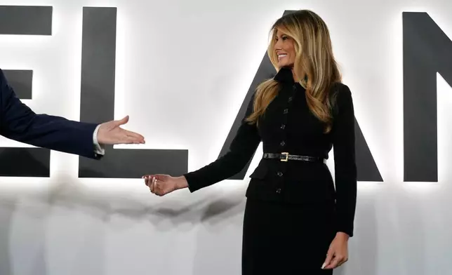 President Donald Trump gestures to first lady Melania Trump as they arrive for the premiere of her movie "Melania" at The John F. Kennedy Memorial Center For The Performing Arts, Thursday, Jan. 29, 2026, in Washington. (AP Photo/Jose Luis Magana)