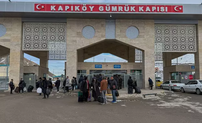 People, mostly Iranians, wait after crossing Kapikoy border post between Turkey and Iran, in Kapikoy, Turkey, Saturday, Jan. 17, 2026. (AP Photo/Serra Yedikardes)