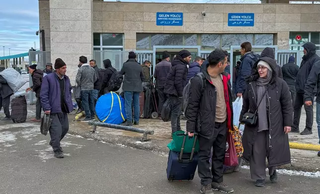 People, mostly Iranians, wait after crossing Kapikoy border post between Turkey and Iran, in Kapikoy, Turkey, Saturday, Jan. 17, 2026. (AP Photo/Serra Yedikardes)